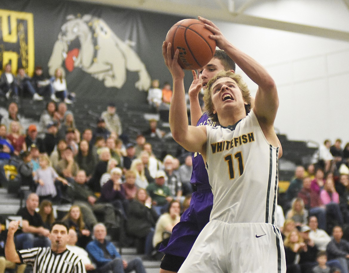 Mark Anderson gets the foul on a late-game layup during the Dogs' home win over Polson on Friday. (Daniel McKay/Whitefish Pilot)