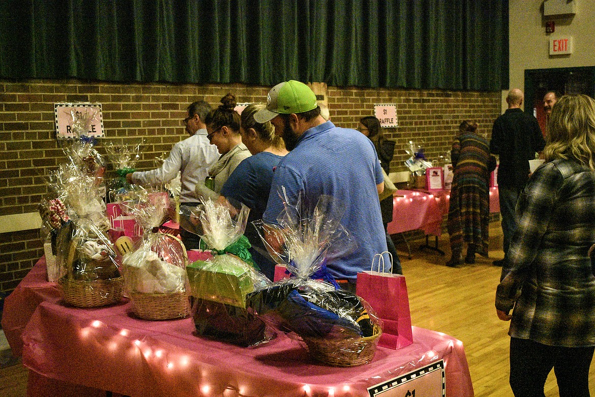 Attendees check out the various raffle prizes at the Libby Chamber of Commerce annual fundraiser and awards banquet Friday. (Ben Kibbey/The Western News)