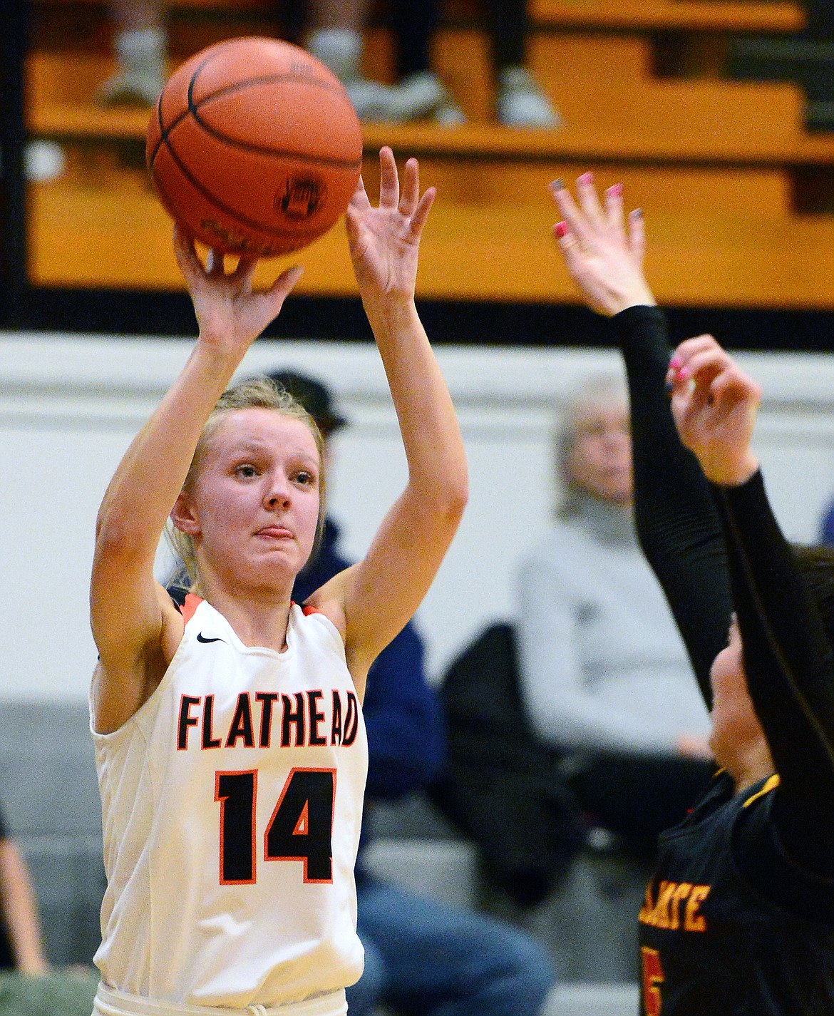 Flathead&#146;s Jenna Johnson (14) shoots a three-pointer with Missoula Hellgate&#146;s Emma Blakely (5) defending at Flathead High School on Thursday. (Casey Kreider/Daily Inter Lake)