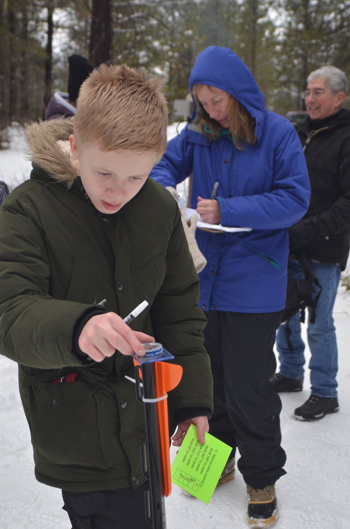 Seventh-grader Kael Brown sights in a compass during the Winter Tracks Festival at the North Shore Campground. (Carolyn Hidy photos/Clark Fork Valley Press)