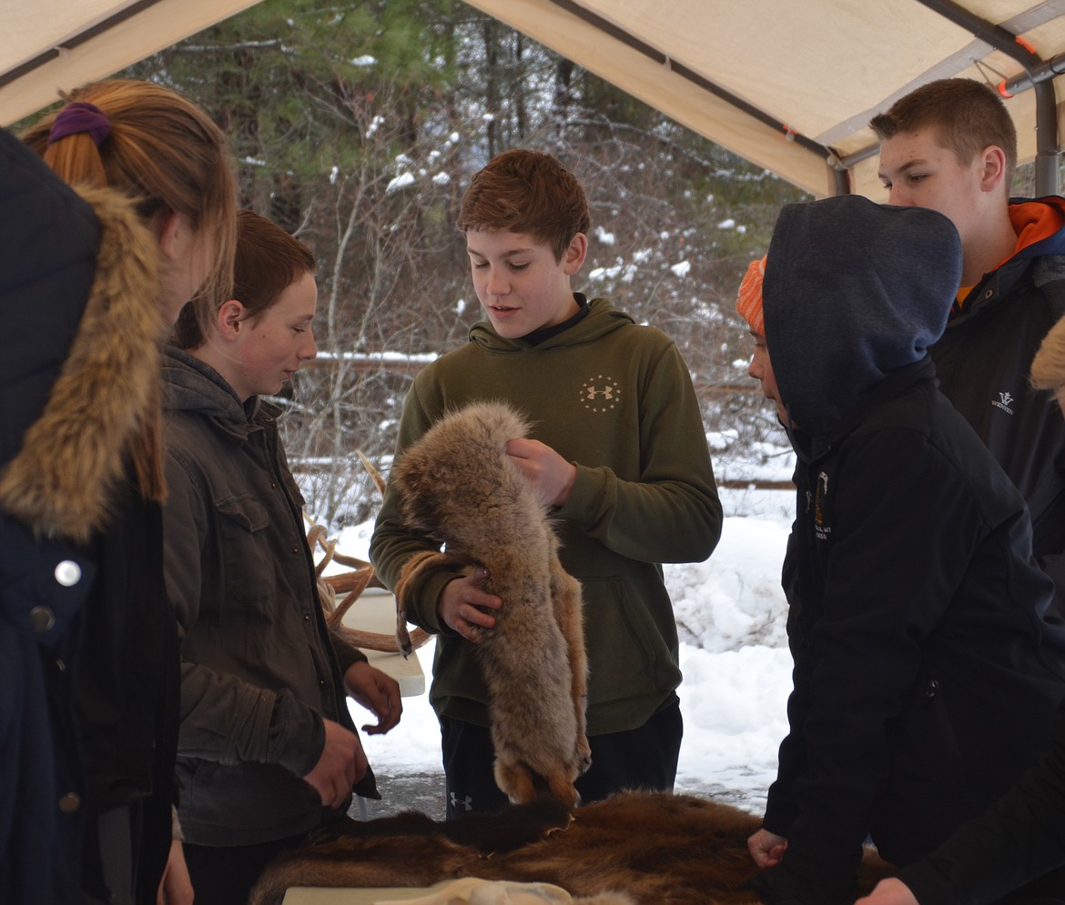 Noxon and Thompson Falls seventh-graders learned how to track such animals as coyotes during the Winter Tracks Festival. Participants are pictured with a coyote pelt.