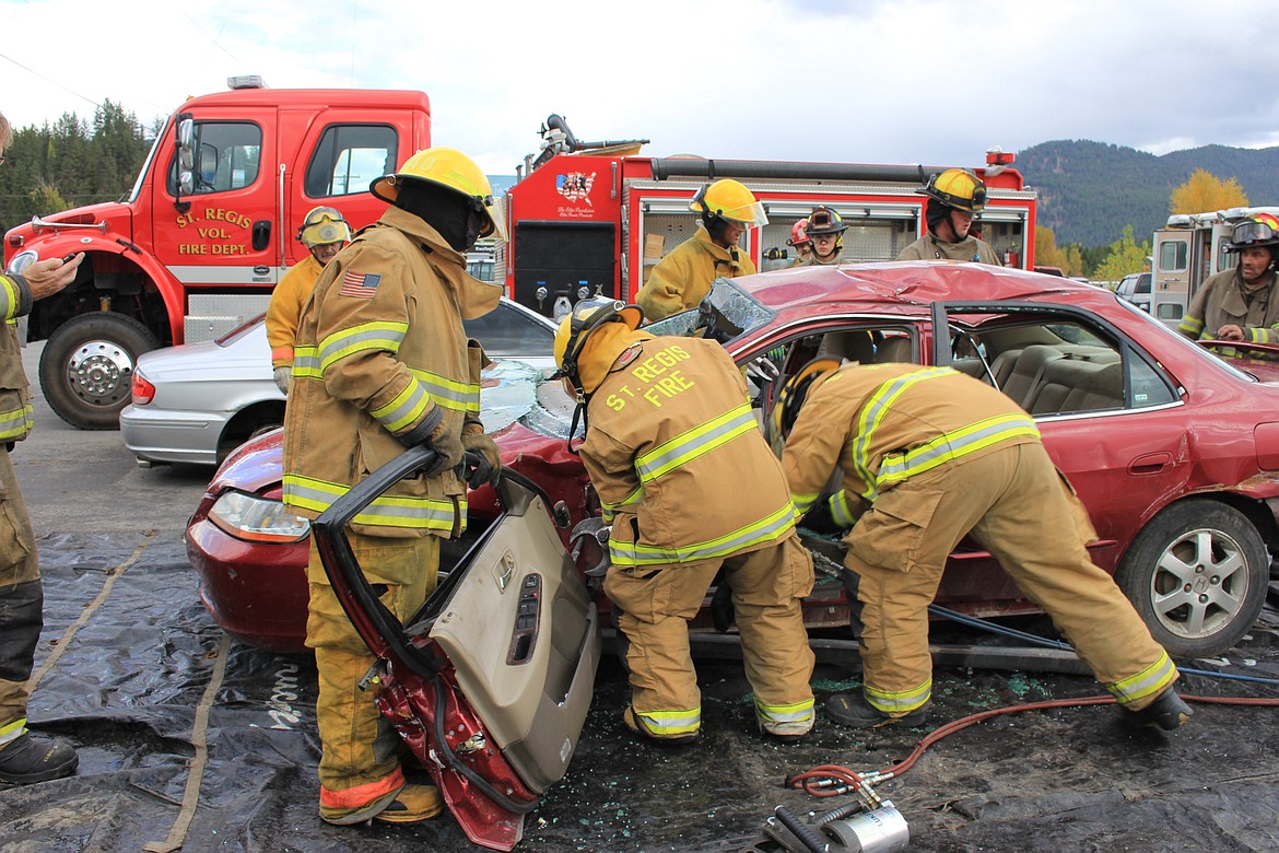 In addition to responding to emergencies, members of the St. Regis Volunteer Fire Department, and other county emergency crews, spend time training and study to earn emergency response certficiations. Here they are training with the Superior Fire Department on extrication techniques from a car accident. (Kathleen Woodford/Mineral Independent)