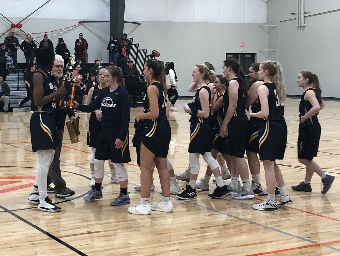 JASON ELLIOTT/Press
North Star League president Ron Miller, back, presents the 1A Division II District 1 championship trophy to Genesis Prep following a 56-46 win over Lakeside in the title game at The Courts at Real Life Ministries in Post Falls on Friday.