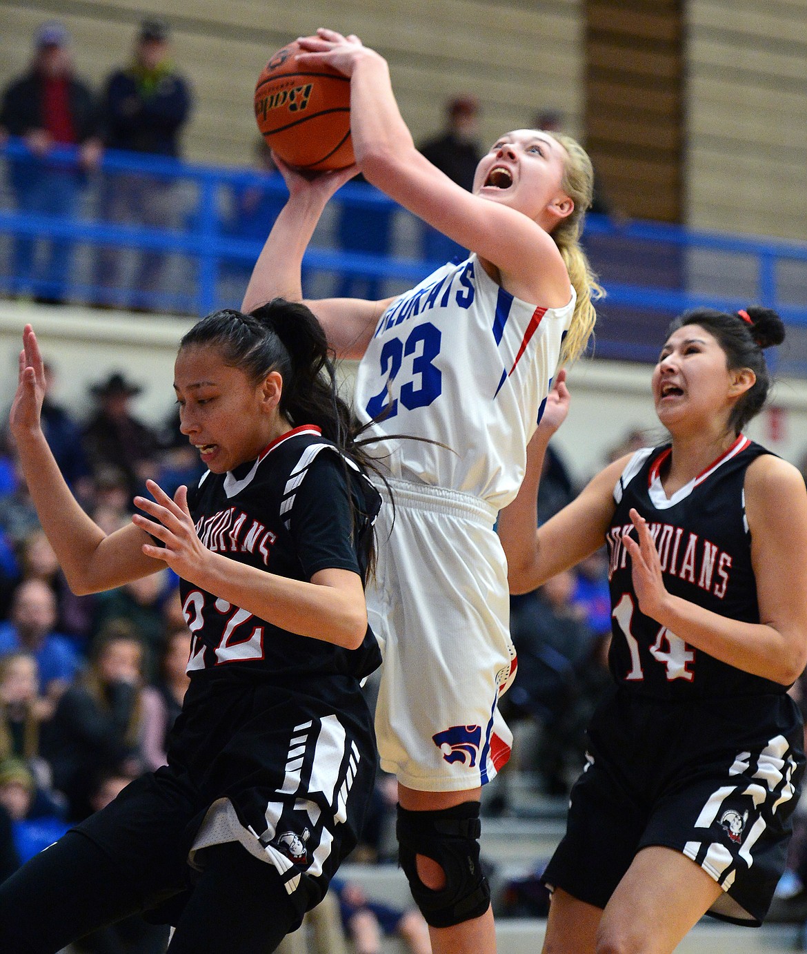 Columbia Falls' Ryley Kehr (23) drives to the basket between Browning defenders Danaiya Polk (22) and Kelsey Mad Plume (14) at Columbia Falls High School on Saturday. (Casey Kreider/Daily Inter Lake)