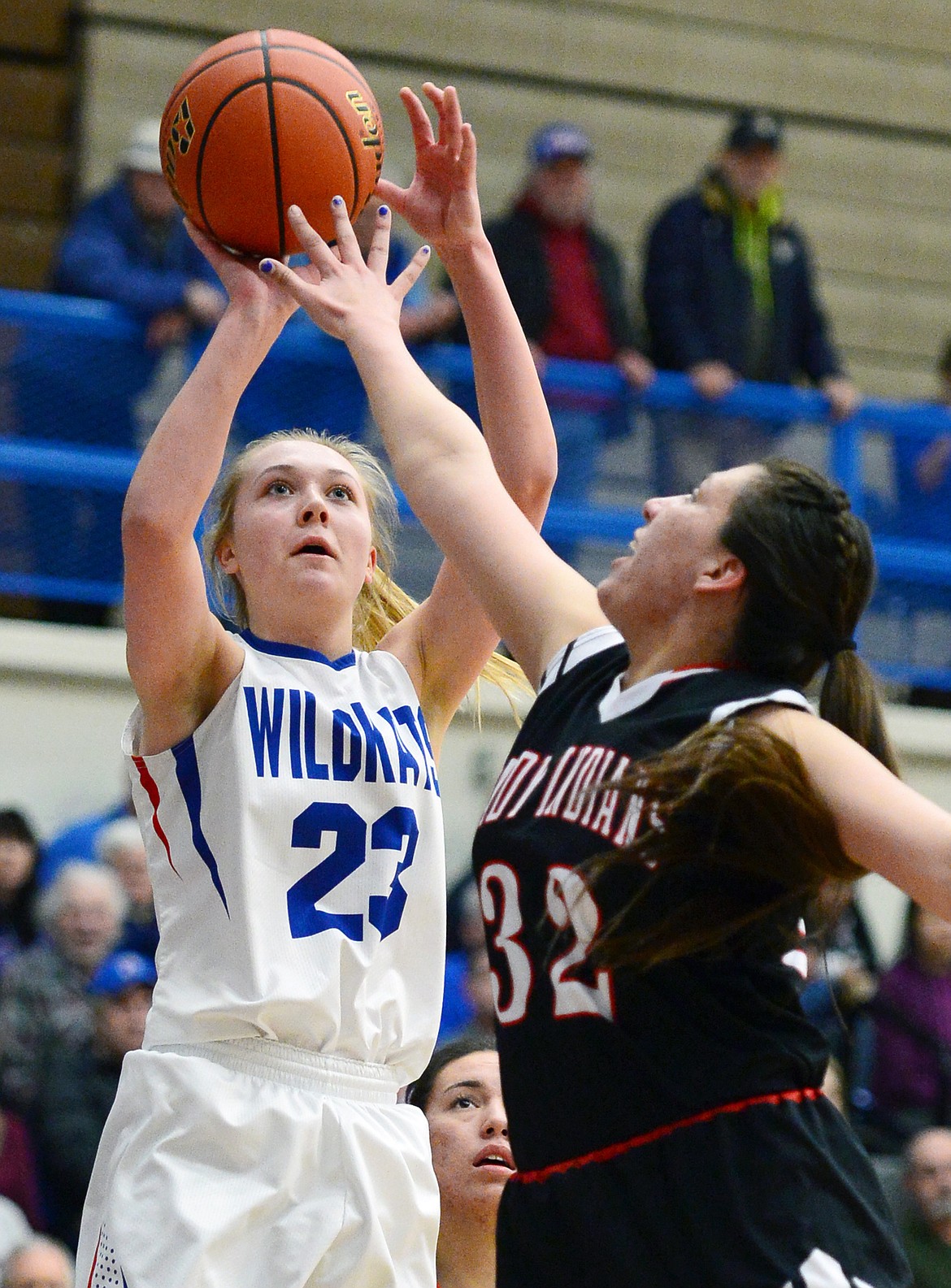 Columbia Falls' Ryley Kehr (23) shoots over Browning's Taylor Jordan (32) at Columbia Falls High School on Saturday. (Casey Kreider/Daily Inter Lake)