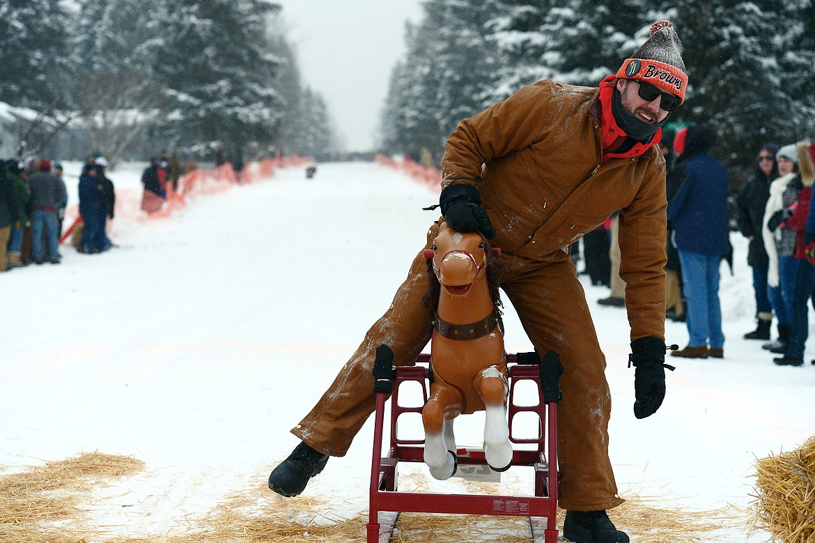 A racer dismounts from his ride after crossing the finish line during Barstool Ski Races at Cabin Fever Days in Martin City on Saturday. (Casey Kreider/Daily Inter Lake)