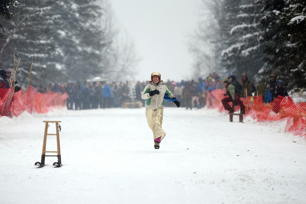 A participant chases her barstool down Sugar Hill after she crashed and it continued skiing along without her during Barstool Ski Races at Cabin Fever Days in Martin City on Saturday. (Casey Kreider/Daily Inter Lake)