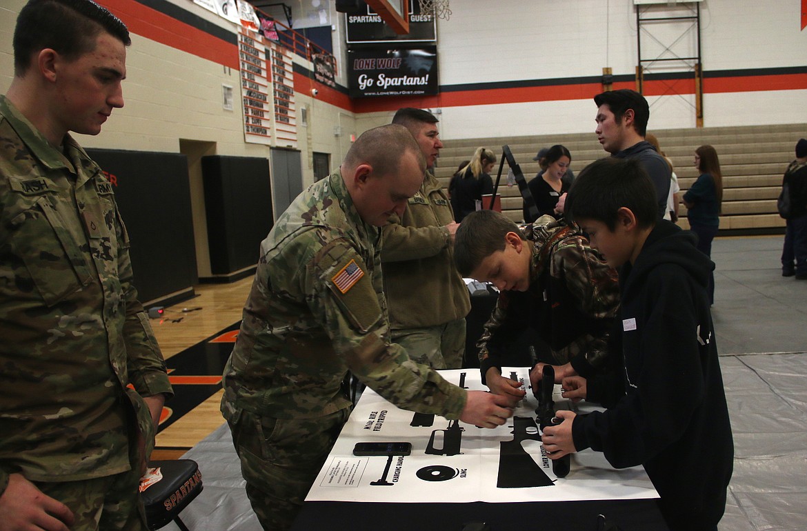 (Photo by MARY MALONE)
The Idaho Army National Guard had a booth set up with a the challenge for teams of putting together an inoperable M16 during the STEaM Olympics at Priest River Lamanna High School last week.