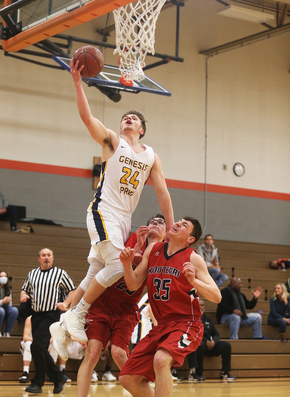 Jonny Hillman of Genesis Prep leaps over Kootenai defenders Marcus Ausman (35) and Garrett Renner.