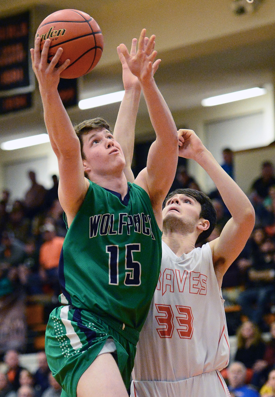 Glacier's Drew Engellant (15) drives to the hoop against Flathead's Gabe Adams (33) during a crosstown matchup at Flathead High School on Tuesday. (Casey Kreider/Daily Inter Lake)