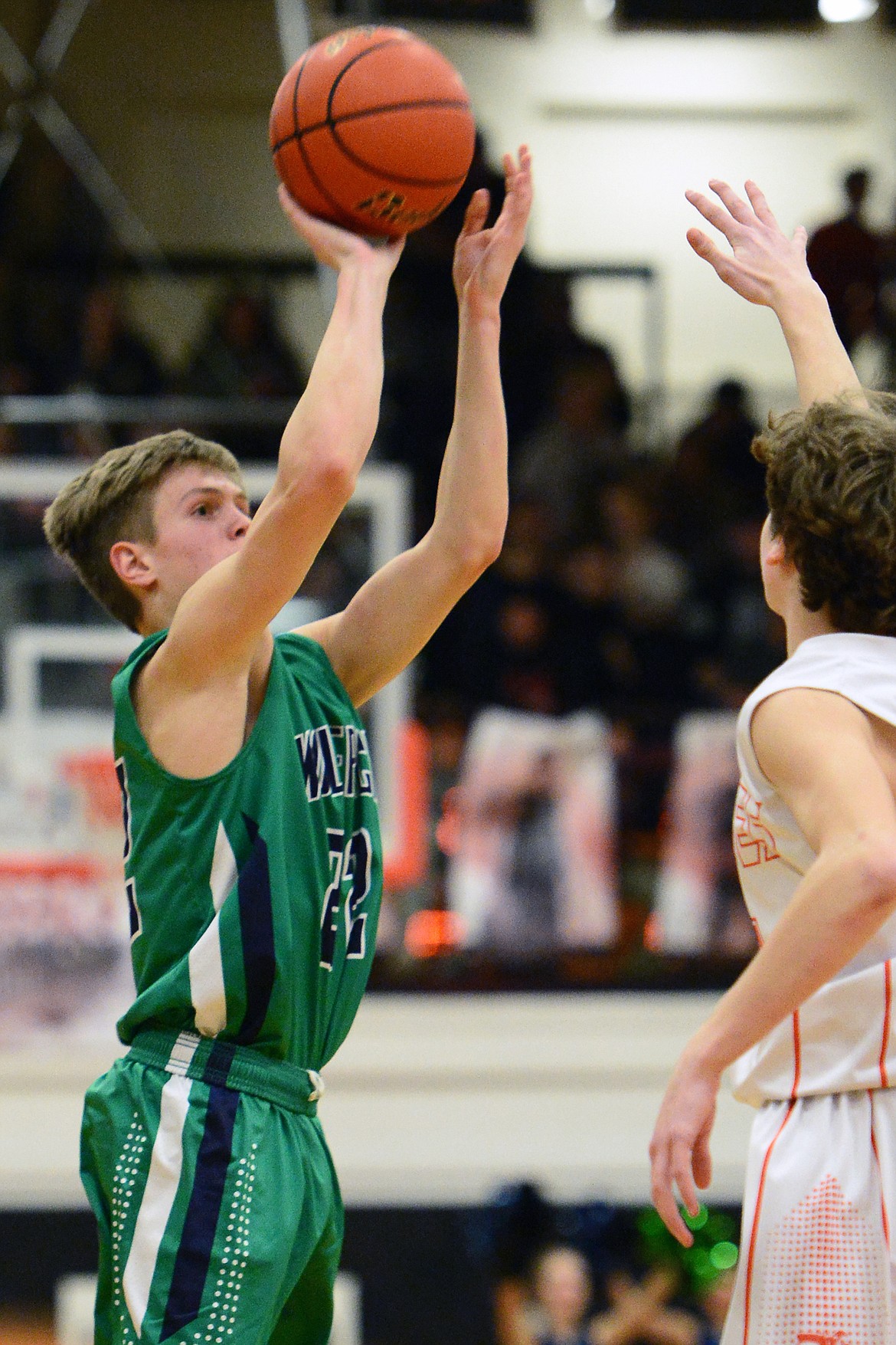 Glacier's Michael Schwarz (22) shoots a three in front of Flathead's Brett Thompson (31) during a crosstown matchup at Flathead High School on Tuesday. (Casey Kreider/Daily Inter Lake)
