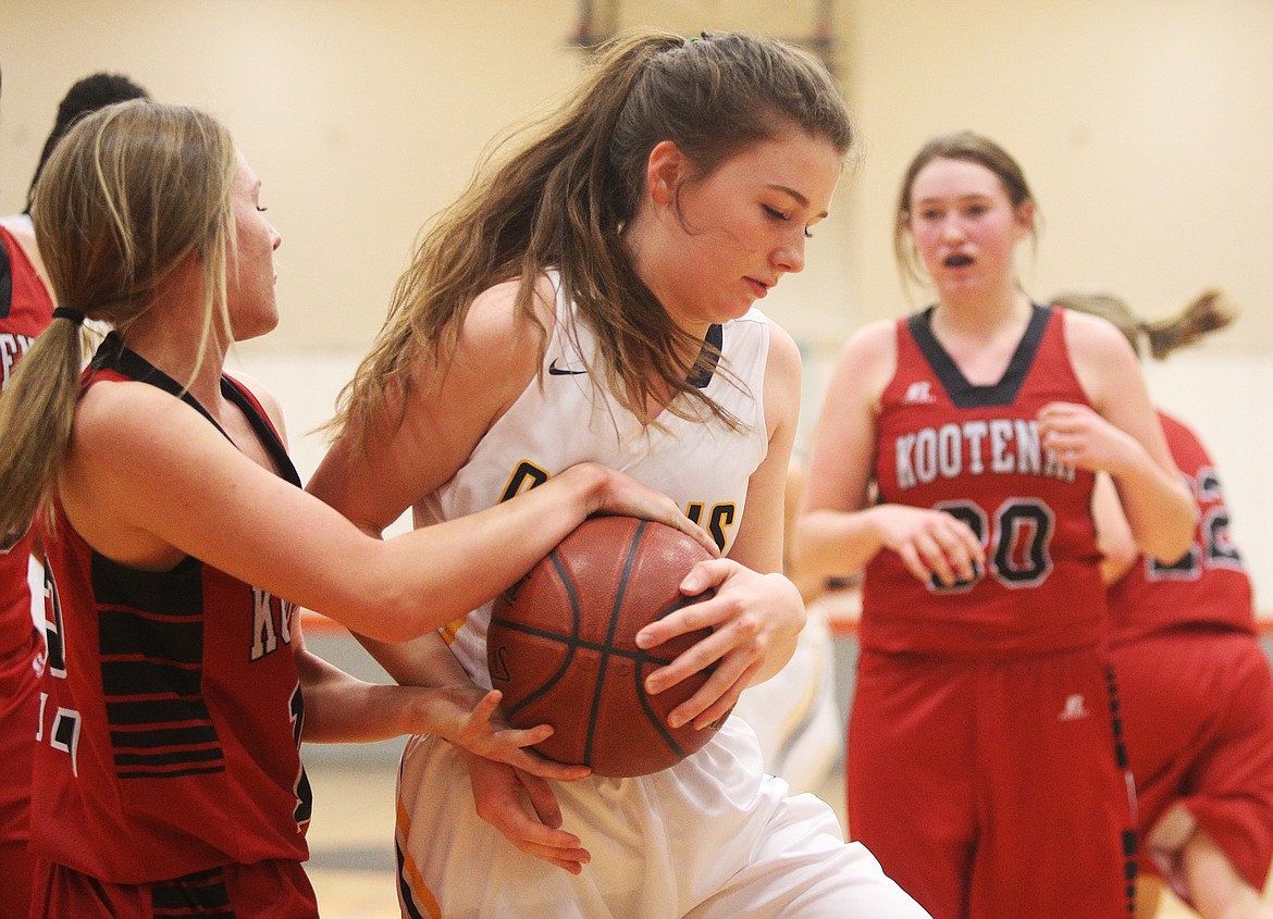 Greta Neely of Genesis Prep and Kootenai&#146;s Tayva Maitland, left, fight for possession of the basketball in the first half of Friday night&#146;s game at Post Falls Middle School. (LOREN BENOIT/Press)