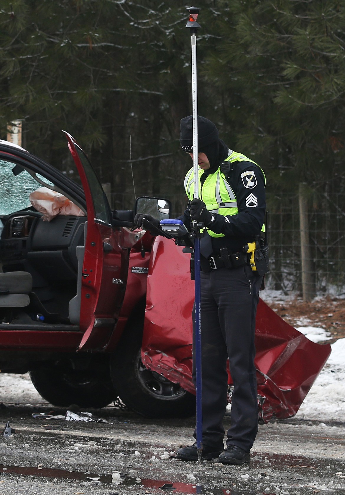 An officer with the Idaho State Police investigates the scene of a collision involving a semi-trailer and truck at the intersection of Highway 53 and Athol Road east of Rathdrum on Monday. (LOREN BENOIT/Press)