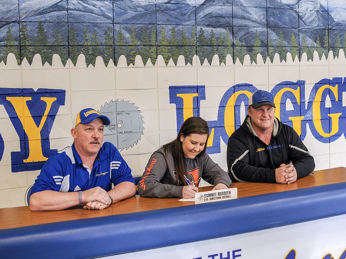 Libby senior Sammee Bradeen signs to play softball at the University of Jamestown Wednesday, flanked by Libby softball Head Coach Dean Thompson and assistant Coach Jeremy Hageness. (Rima Austin/The Western News)