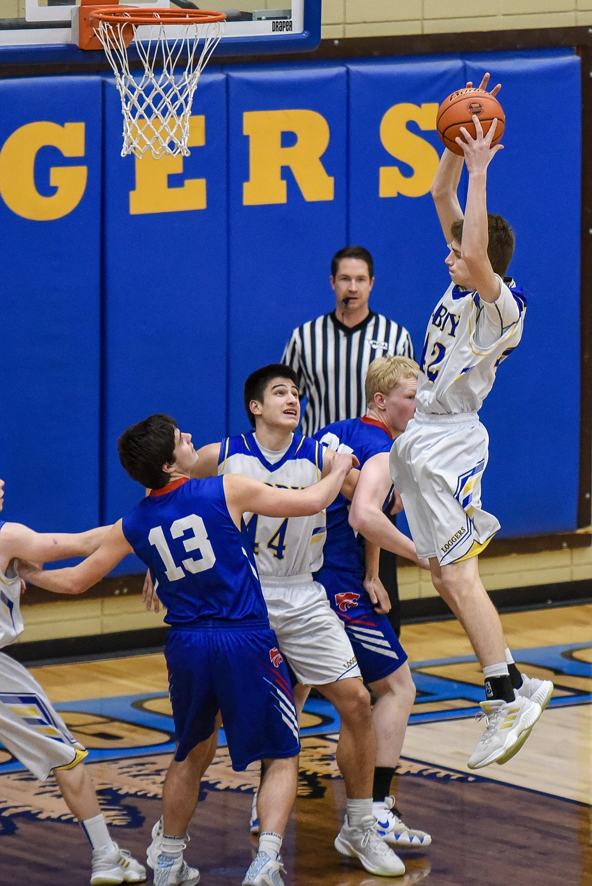 Libby junior Keith Johnson goes high to make a the rebound early in the first quarter Friday against Columbia Falls. (Ben Kibbey/The Western News)