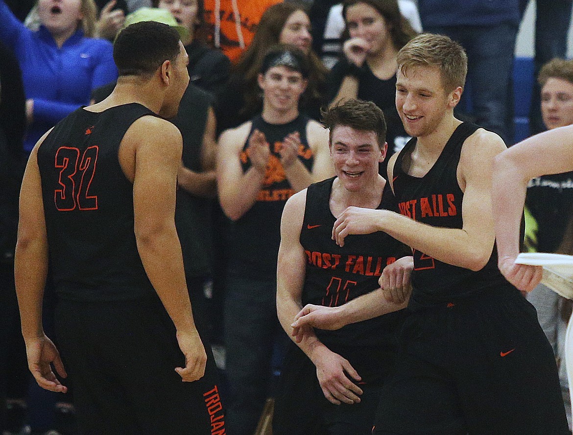 Post Falls players Terrell Mitchell, left, Cole Rutherfod and Colby Gannett celebrate their 67-62 win over Coeur d'Alene Thursday night at Viking Court. (LOREN BENOIT/Press)