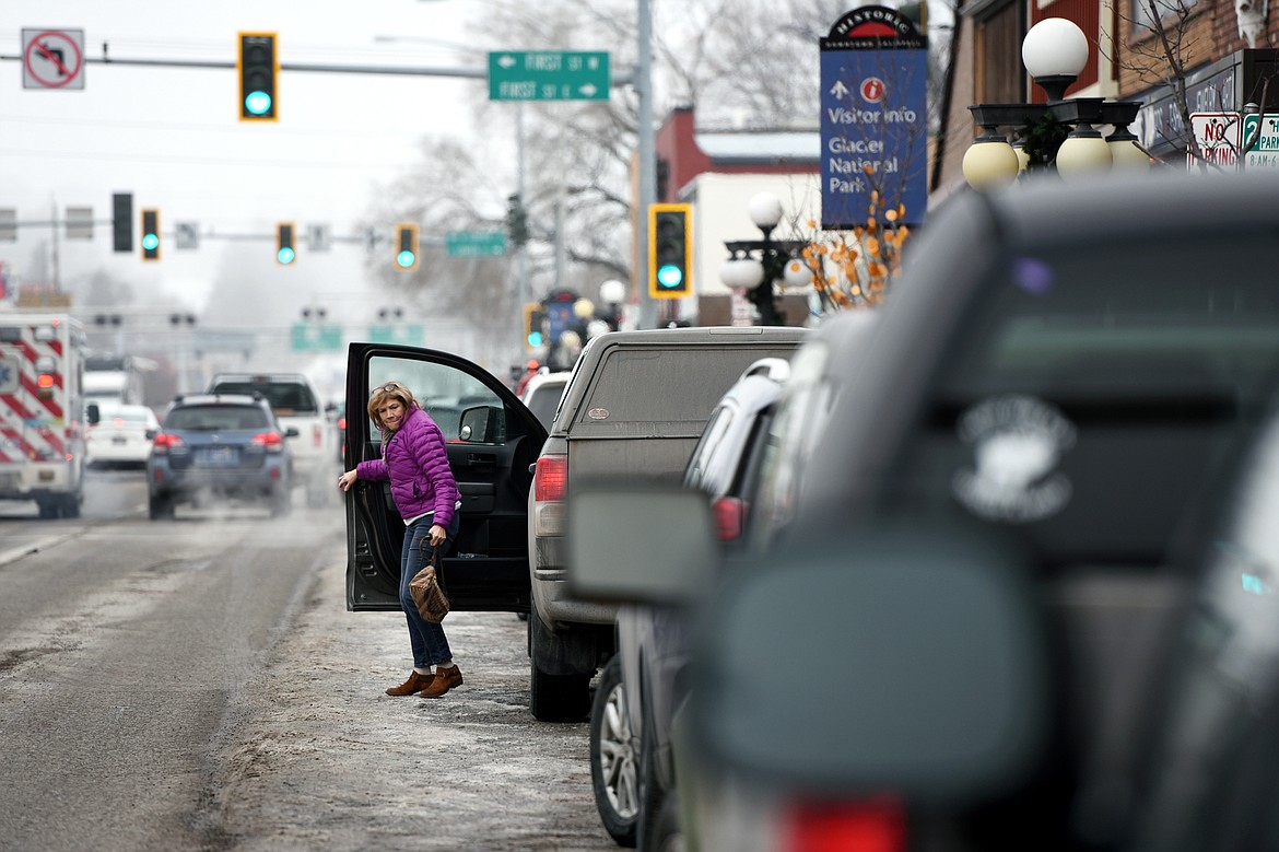 A woman exits a truck after parking along South Main Street in Kalispell on Jan. 30.