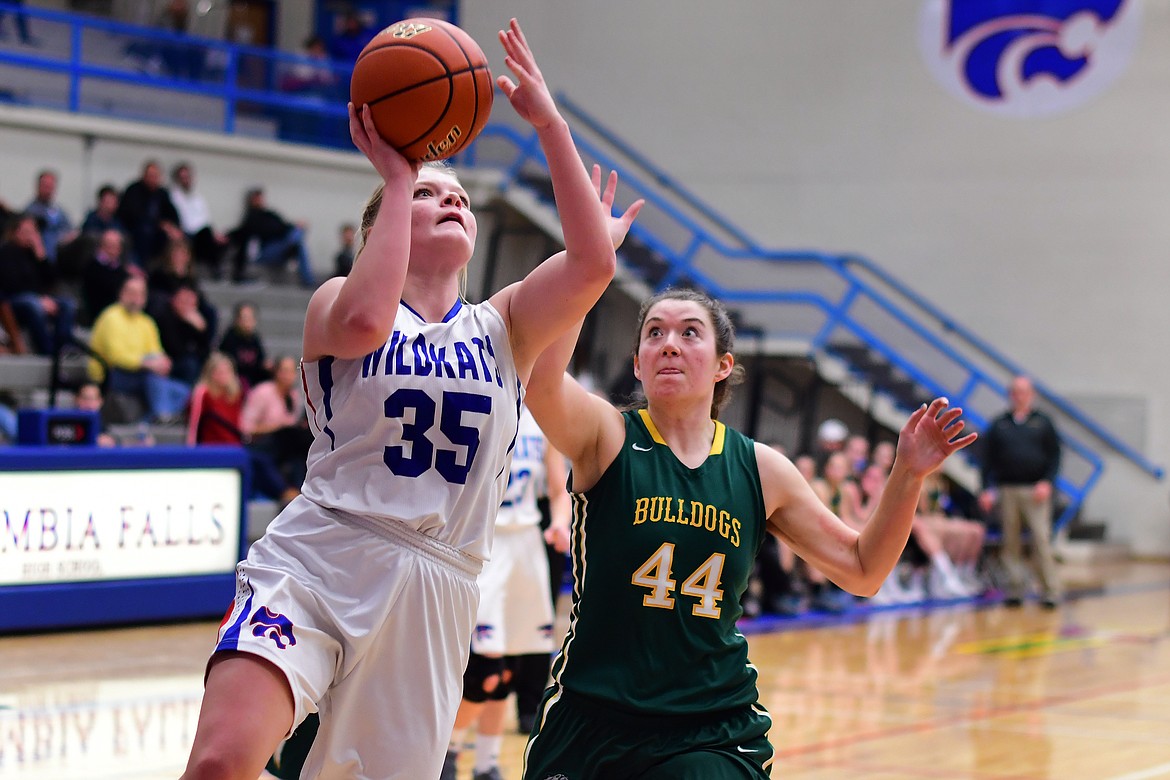 Trista Cowan takes the ball past Whitefish&#146;s Marlee Bender for two points Thursday. (Jeremy Weber photo)