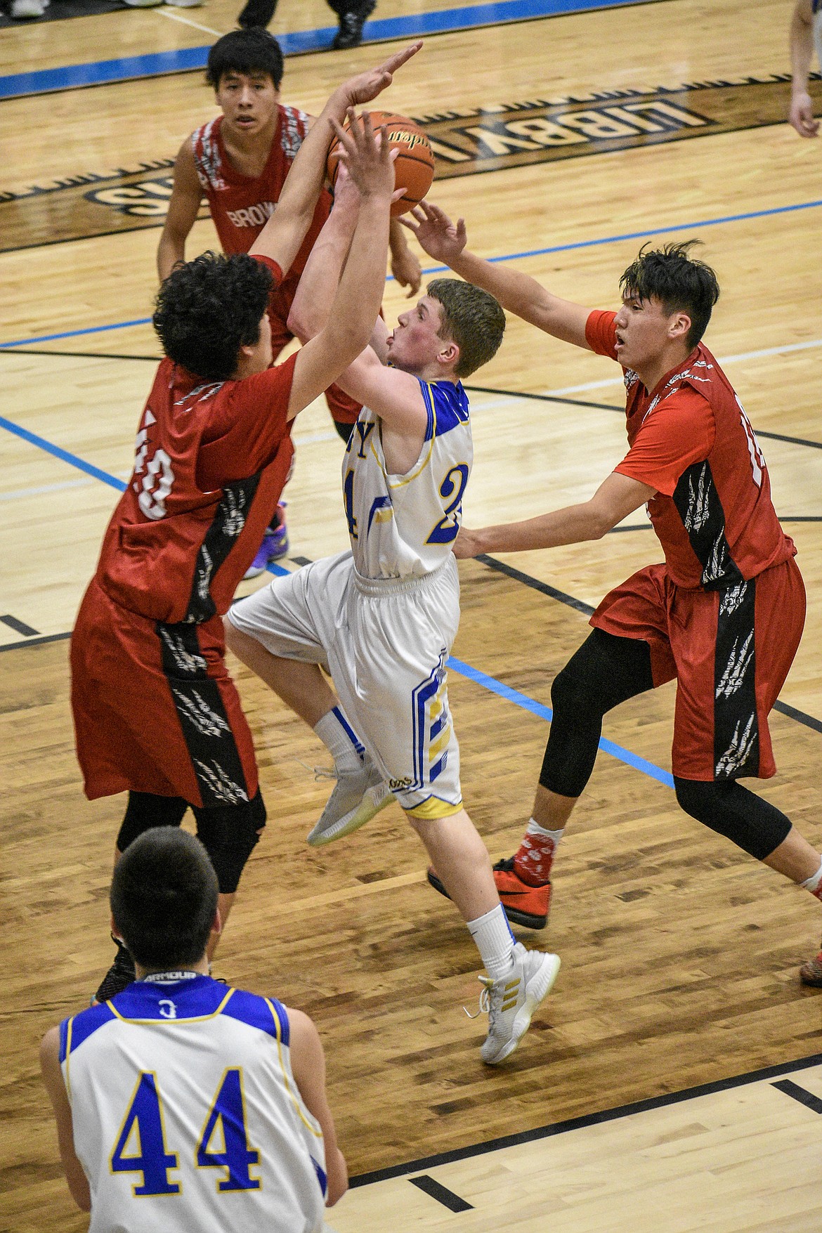 Libby sophomore Jay Beagle pushes through the Browning defenders to make a layup early in the fourth quarter against Browning Saturday. (Ben Kibbey/The Western News)