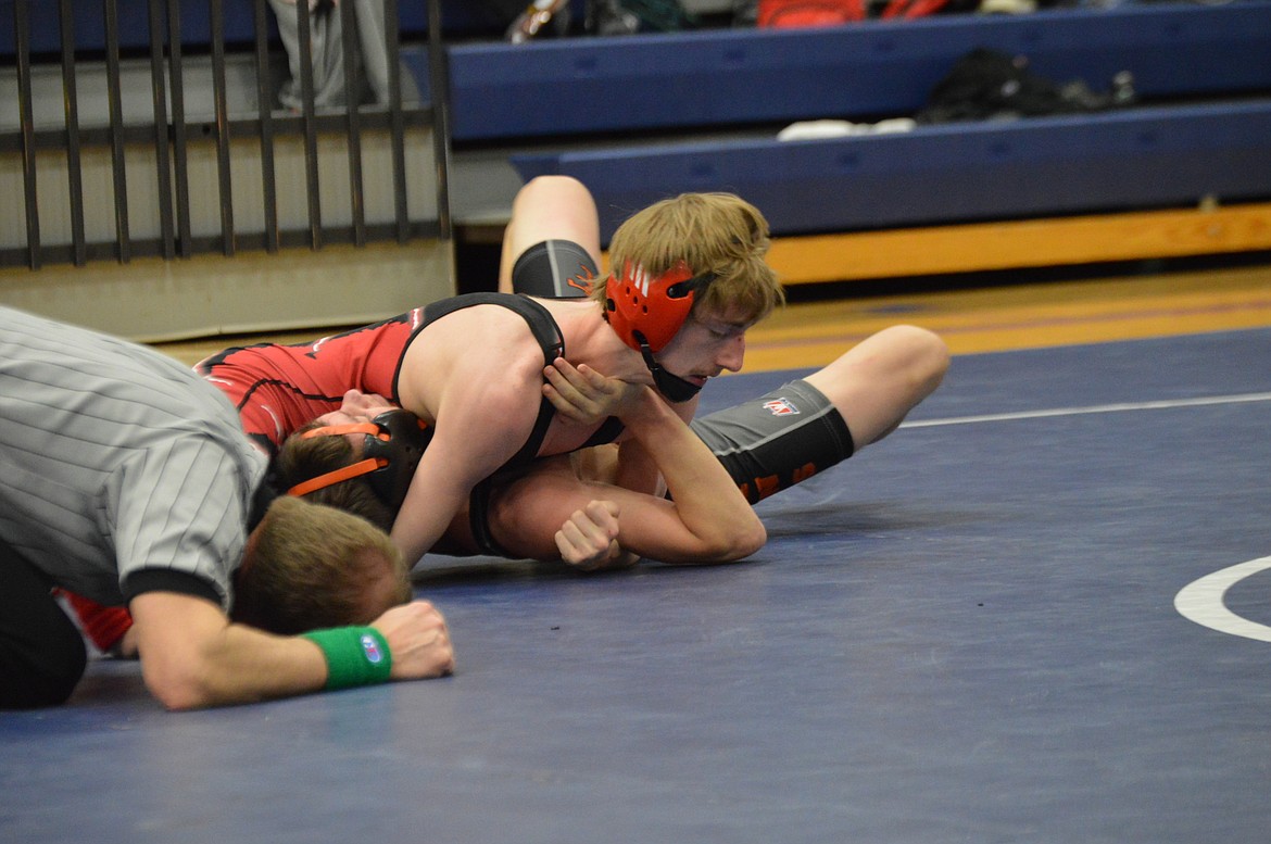 Wrestling Photos by Teri Eixenberger/ Austin McKinnon rolls his opponent on his back for a pin during the Bonners Ferry Tournament.