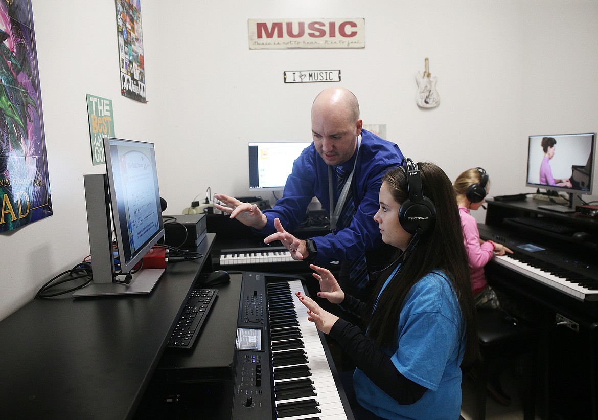 Music teacher Spencer Normington helps fifth-grader Kambryn Powers with her piano technique during class Thursday at Ramsey Magnet School of Science. (LOREN BENOIT/Press)