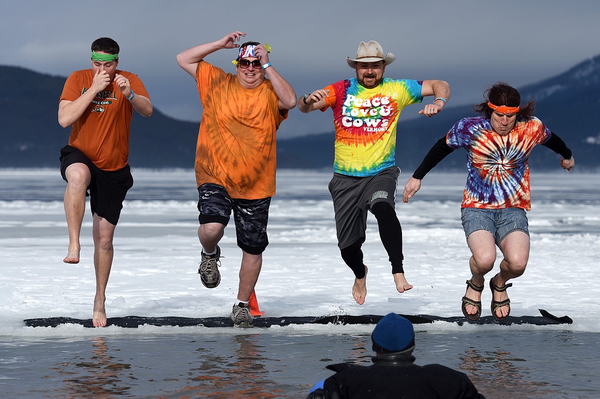 Participants leap into Whitefish Lake during the Whitefish Winter Carnival Penguin Plunge 2019 at City Beach on Saturday. (Casey Kreider/Daily Inter Lake)