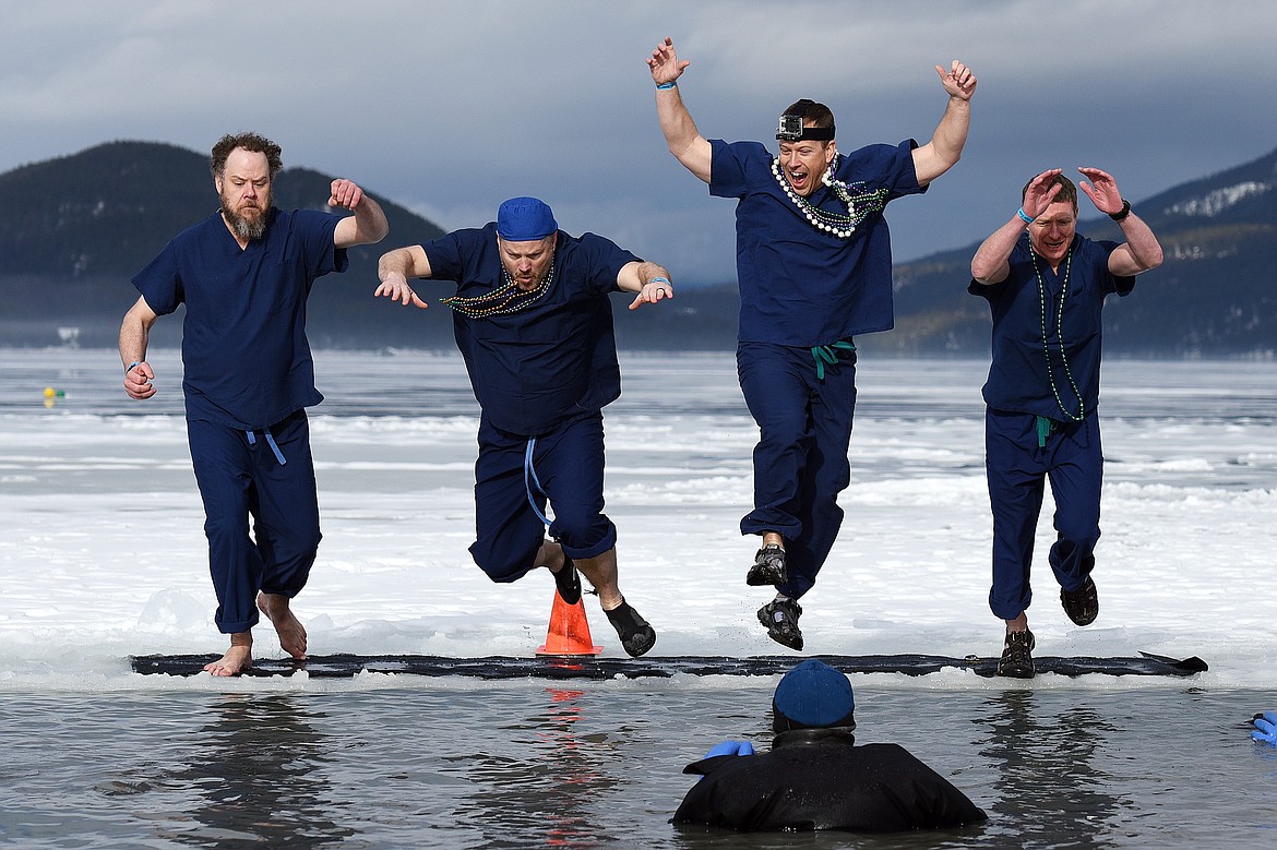 Participants leap into Whitefish Lake during the Whitefish Winter Carnival Penguin Plunge 2019 at City Beach on Saturday. (Casey Kreider/Daily Inter Lake)