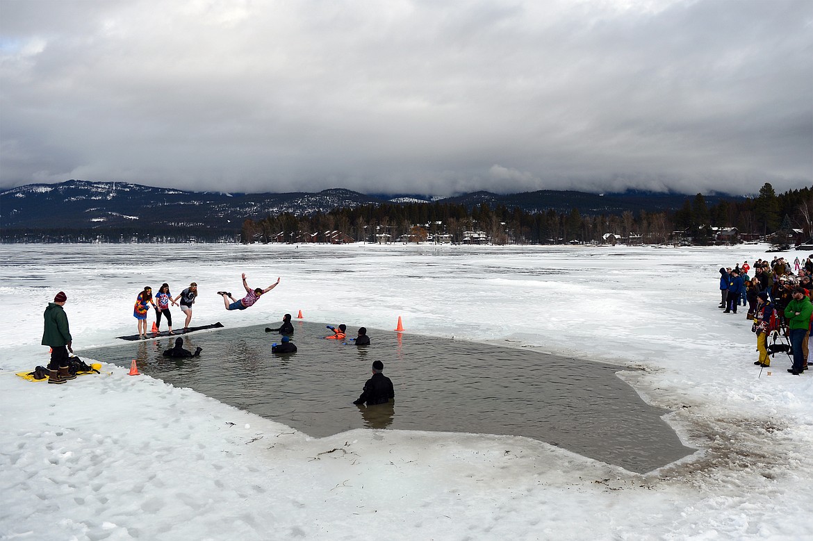 A participant bellyflops into Whitefish Lake during the Whitefish Winter Carnival Penguin Plunge 2019 on Saturday. (Casey Kreider/Daily Inter Lake)