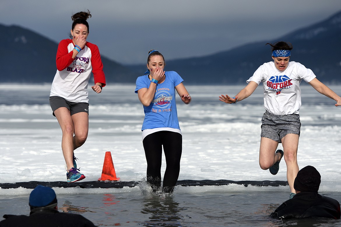 Participants leap into Whitefish Lake during the Whitefish Winter Carnival Penguin Plunge 2019 at City Beach on Saturday. (Casey Kreider/Daily Inter Lake)