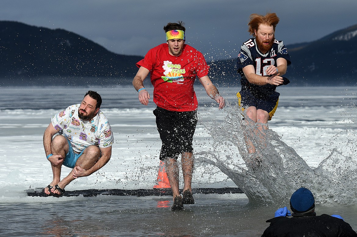 Participants leap into Whitefish Lake during the Whitefish Winter Carnival Penguin Plunge 2019 at City Beach on Saturday. (Casey Kreider/Daily Inter Lake)