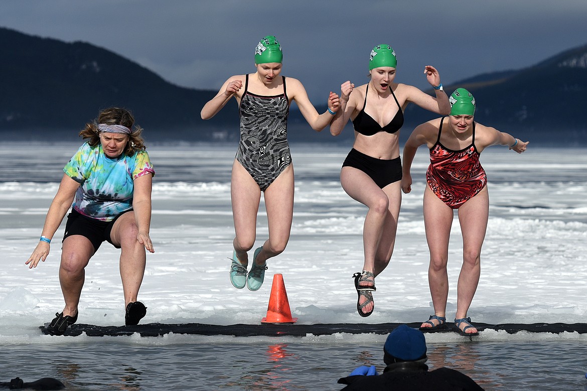Participants leap into Whitefish Lake during the Whitefish Winter Carnival Penguin Plunge 2019 at City Beach on Saturday. (Casey Kreider/Daily Inter Lake)