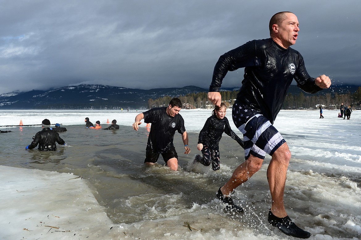 Participants step out of Whitefish Lake during the Whitefish Winter Carnival Penguin Plunge 2019 on Saturday. (Casey Kreider/Daily Inter Lake)