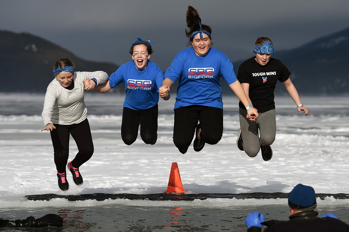 Participants leap into Whitefish Lake during the Whitefish Winter Carnival Penguin Plunge 2019 at City Beach on Saturday. (Casey Kreider/Daily Inter Lake)