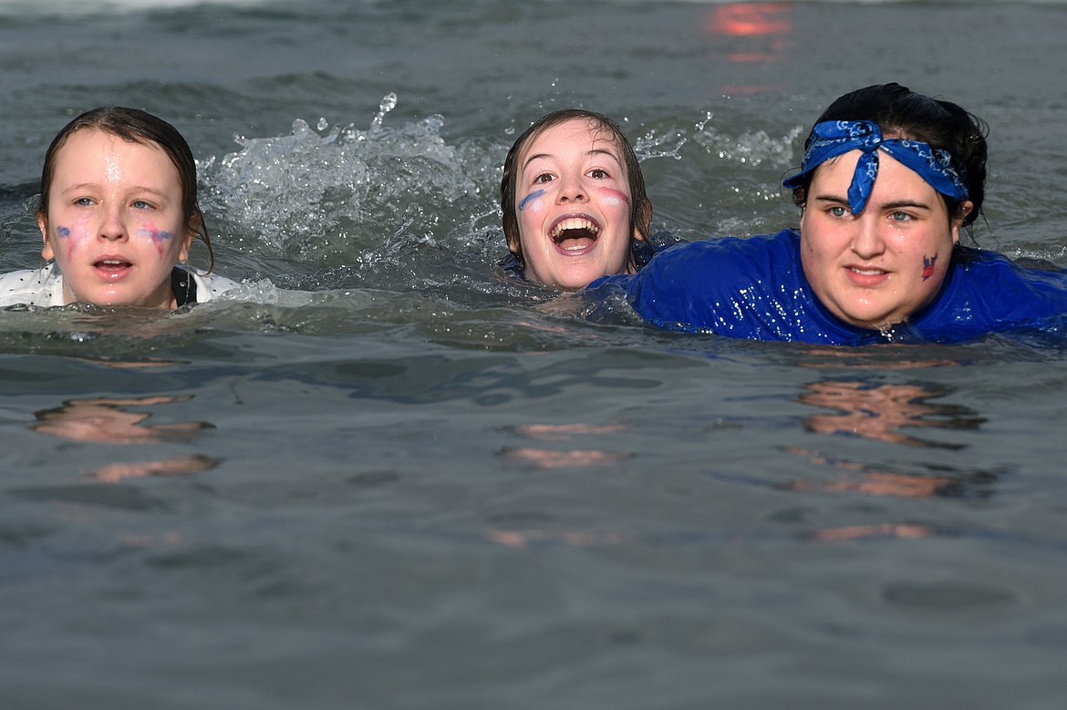 Participants swim to shore after leaping into Whitefish Lake during the Whitefish Winter Carnival Penguin Plunge 2019 at City Beach on Saturday. (Casey Kreider/Daily Inter Lake)