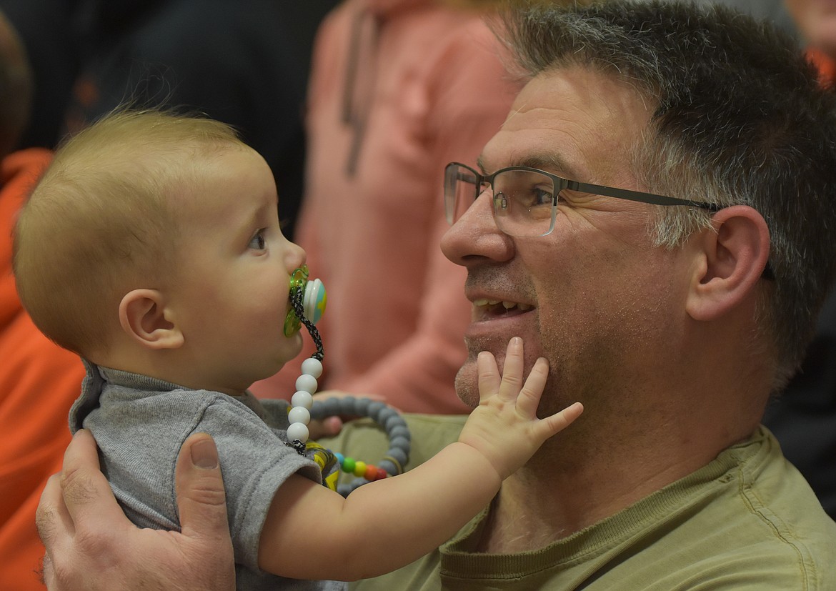 BASKETBALL FANS get an early start supporting their teams in Sanders County. A newcomer is 6-month-old Reed Standeford of Plains. He made the trip to Hot Springs last Friday with his mom, Krista. Above, Reed was attracted to family friend Matt Selicka, maybe because he liked to grab Matt&#146;s glasses. (Joe Sova/Clark Fork Valley Press)