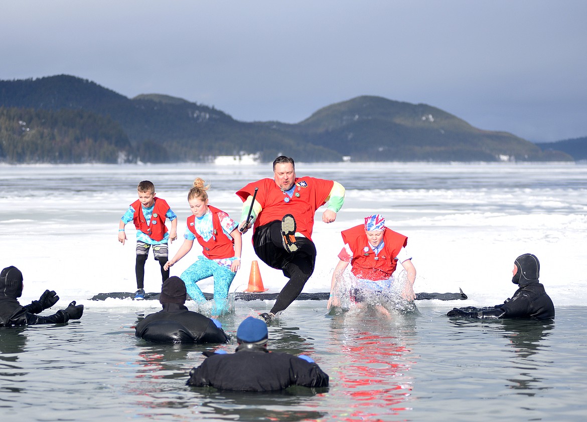 Participants jump into the icy waters of Whitefish Lake Saturday morning during the Whitefish Winter Carnival Penguin Plunge, which benefits Special Olympics Montana. (Heidi Desch/Whitefish Pilot)