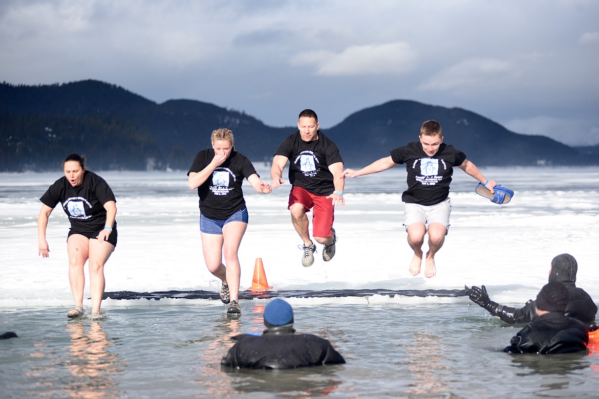 Members of the Flathead County Sheriff&#146;s Office team jump into the icy waters of Whitefish Lake Saturday morning during the Whitefish Winter Carnival Penguin Plunge, which benefits Special Olympics Montana. (Heidi Desch/Whitefish Pilot)