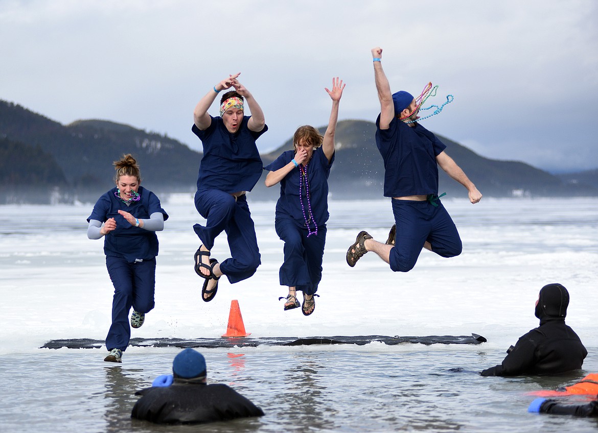 Members of the North Valley Hospital team jump into the icy waters of Whitefish Lake Saturday morning during the Whitefish Winter Carnival Penguin Plunge, which benefits Special Olympics Montana. (Heidi Desch/Whitefish Pilot)