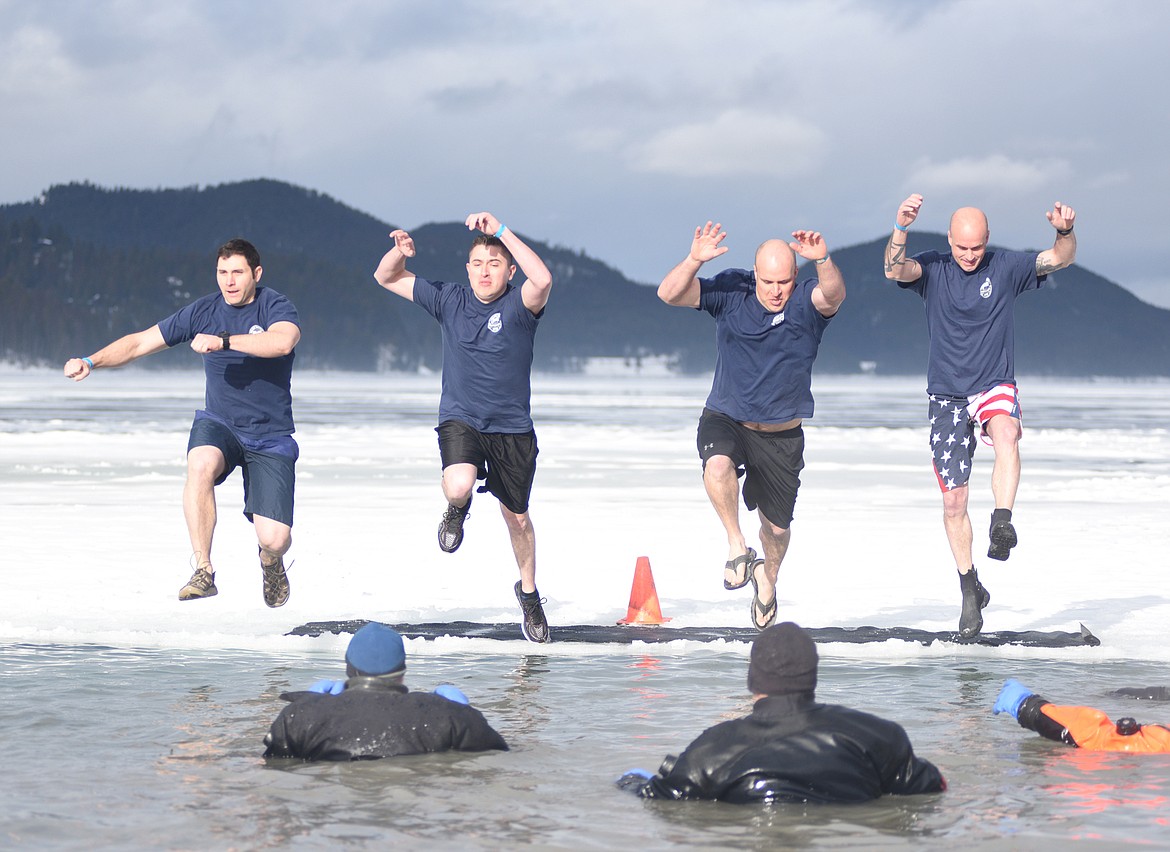 Members of the Whitefish Police Department team jump into the icy waters of Whitefish Lake Saturday morning during the Whitefish Winter Carnival Penguin Plunge, which benefits Special Olympics Montana. (Heidi Desch/Whitefish Pilot)