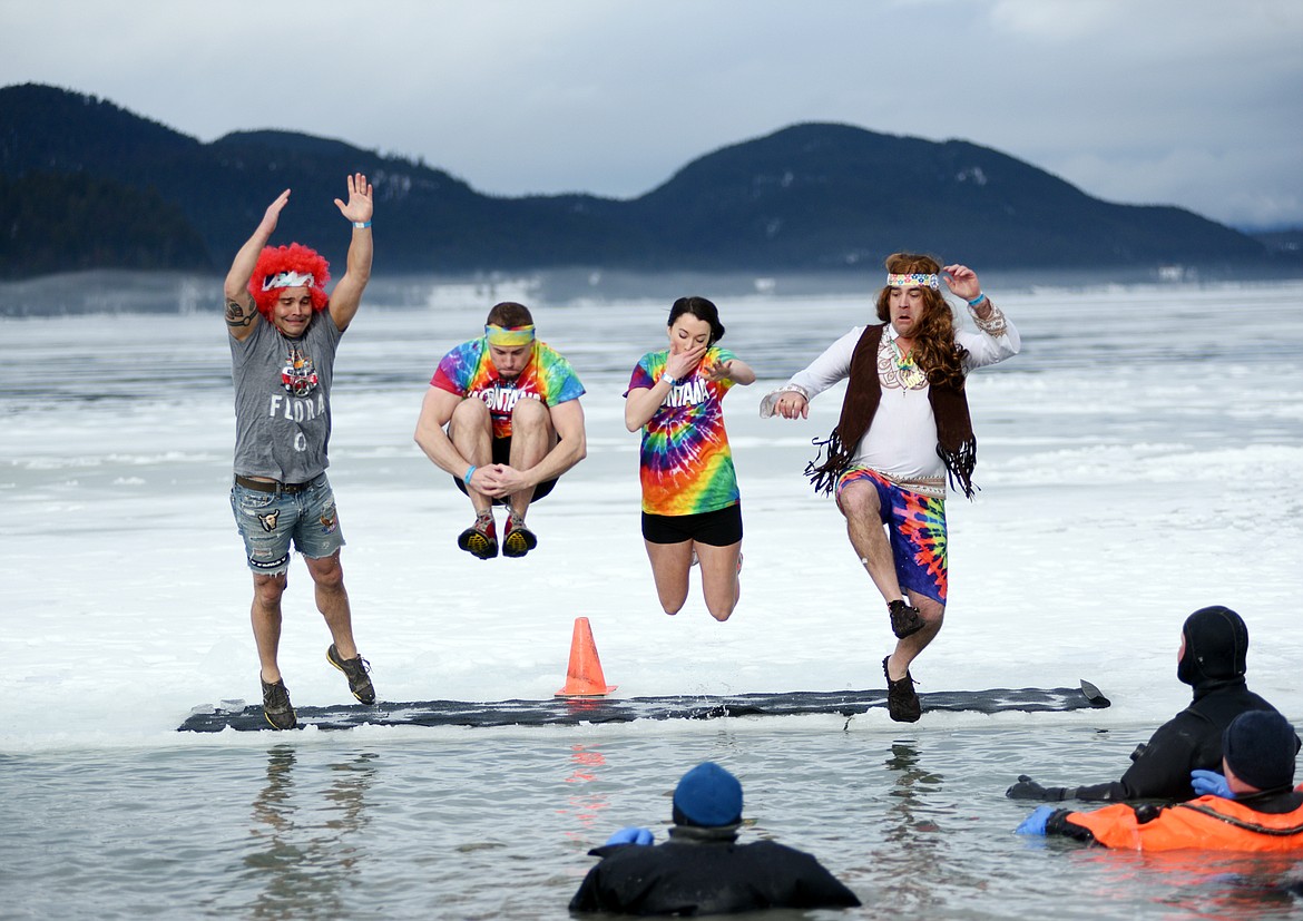 Members of the National Parks Realty team jump into the icy waters of Whitefish Lake Saturday morning during the Whitefish Winter Carnival Penguin Plunge, which benefits Special Olympics Montana. (Heidi Desch/Whitefish Pilot)