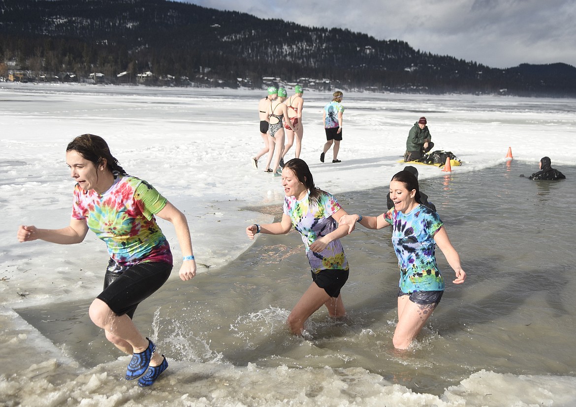 Participants emerge from the icy waters of Whitefish Lake Saturday morning during the Whitefish Winter Carnival Penguin Plunge, which benefits Special Olympics Montana. (Heidi Desch/Whitefish Pilot)