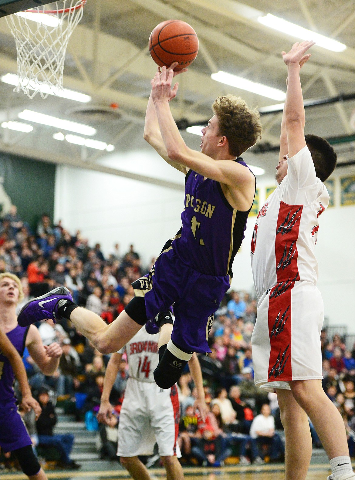 Polson's Robin Erickson (11) drives to the hoop with Browning's Latrell Bullchild (30) defending during the Northwest A District boys' championship game at Whitefish High School on Saturday. Browning won, 78-50. (Casey Kreider/Daily Inter Lake)