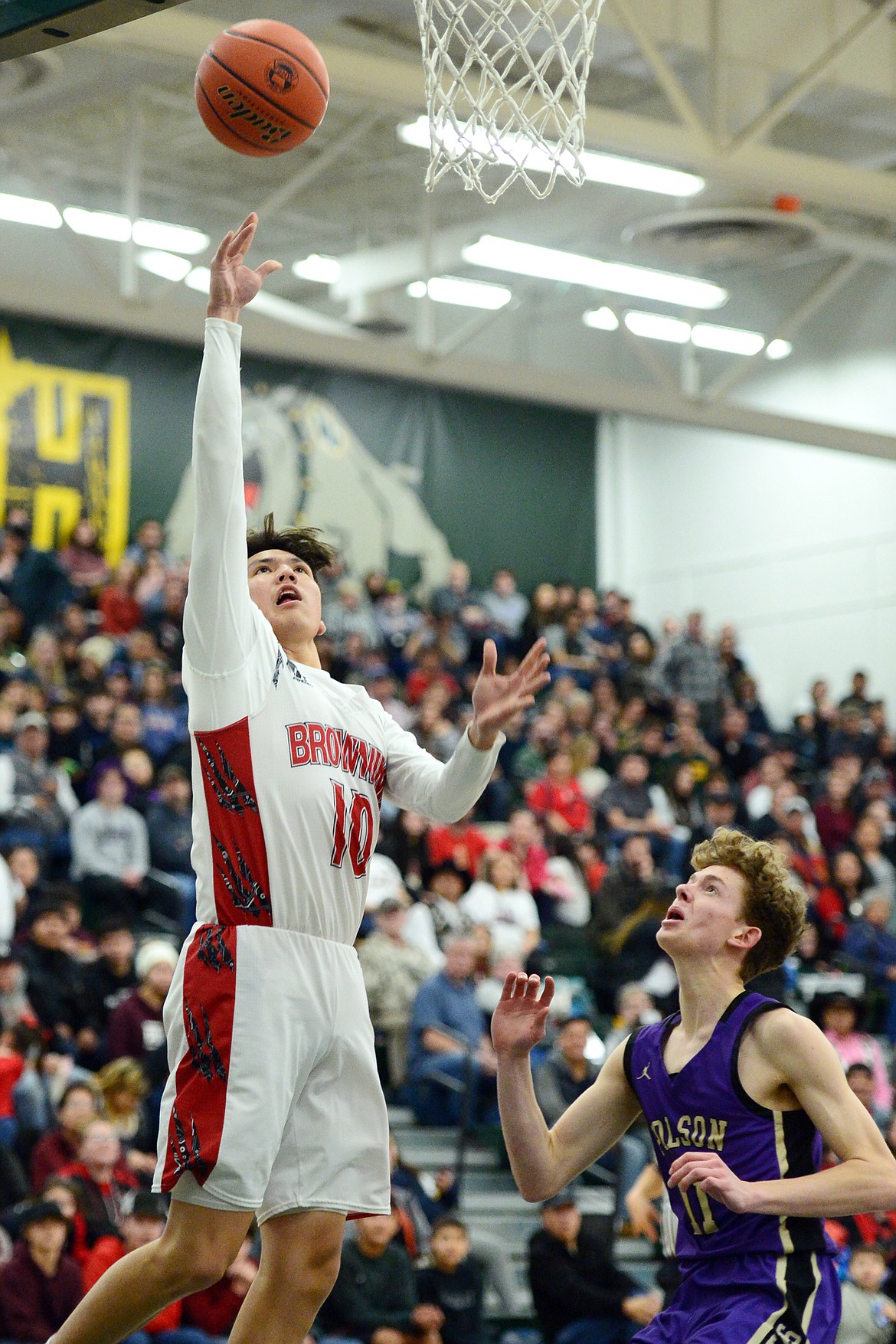 Browning's Riley Spoonhunter (10) drives to the hoop against Polson's Robin Erickson (11) during the Northwest A District boys' championship game at Whitefish High School on Saturday. Browning won, 78-50. (Casey Kreider/Daily Inter Lake)