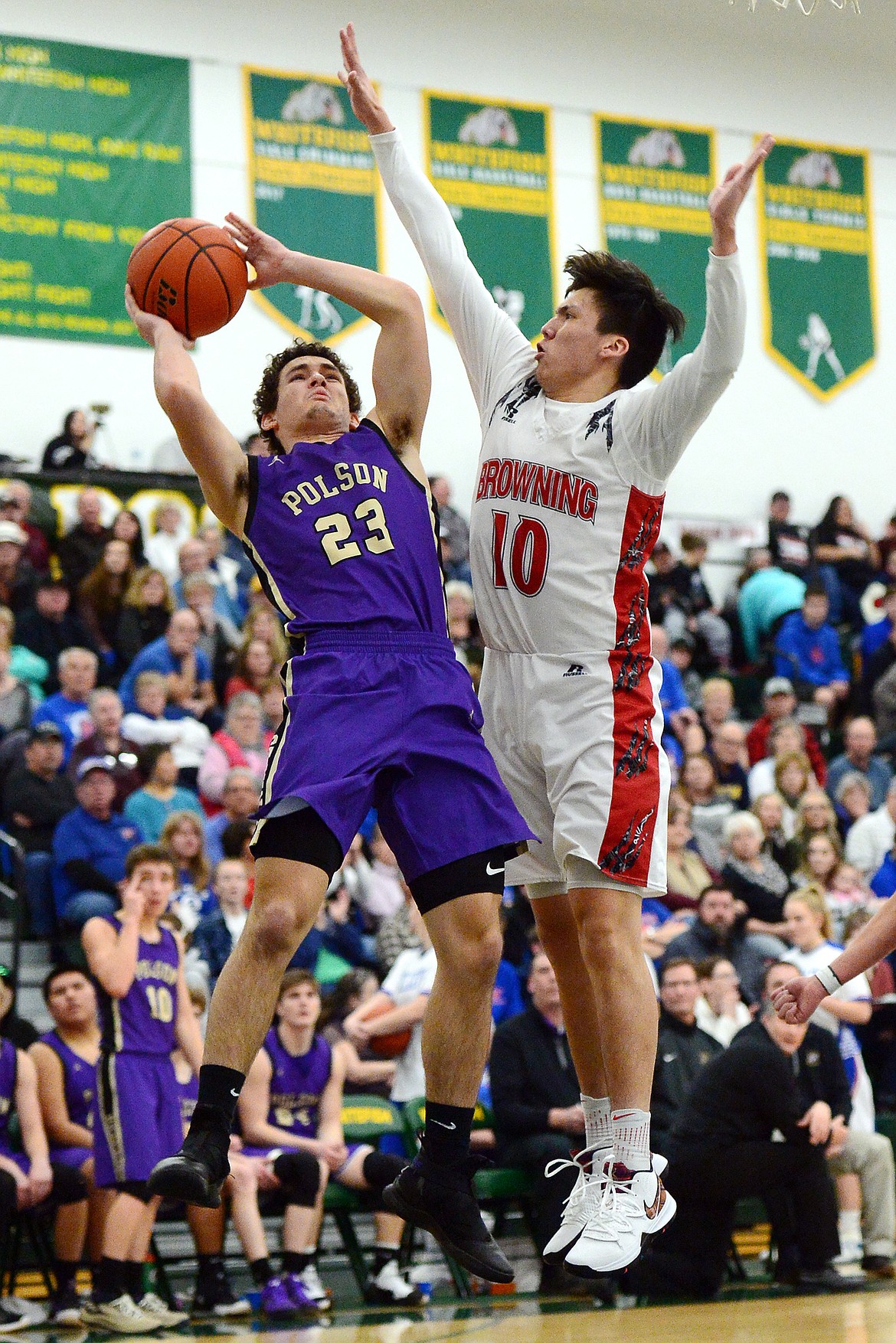 Polson's Parker Toth (23) goes up for a shot against Browning's Riley Spoonhunter (10) during the Northwest A District boys' championship game at Whitefish High School on Saturday. Browning won, 78-50. (Casey Kreider/Daily Inter Lake)