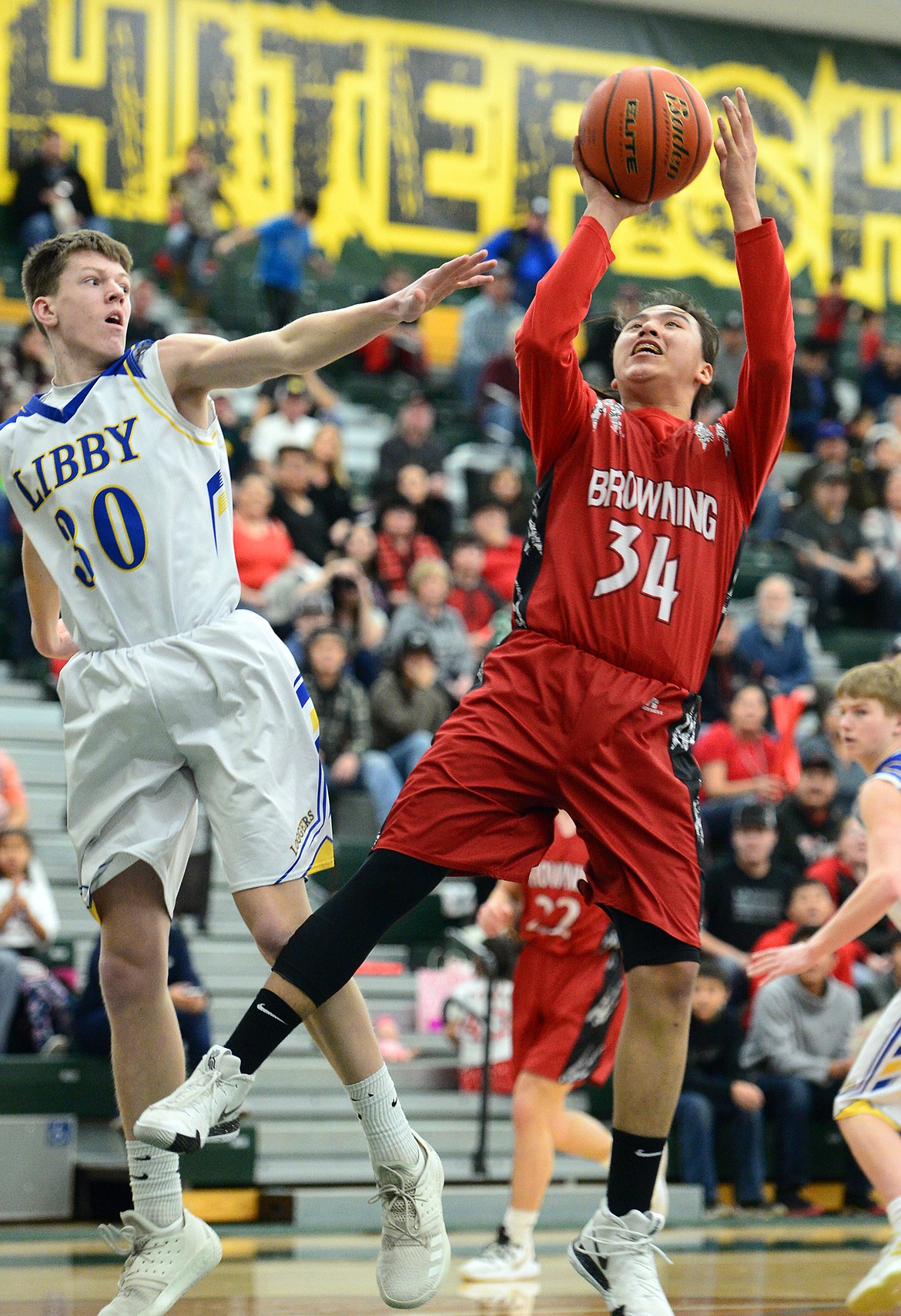 Browning's Deion Mad Plume (34) shoots with Libby's Caden Williams (30) defending at Whitefish High School on Friday. (Casey Kreider/Daily Inter Lake)