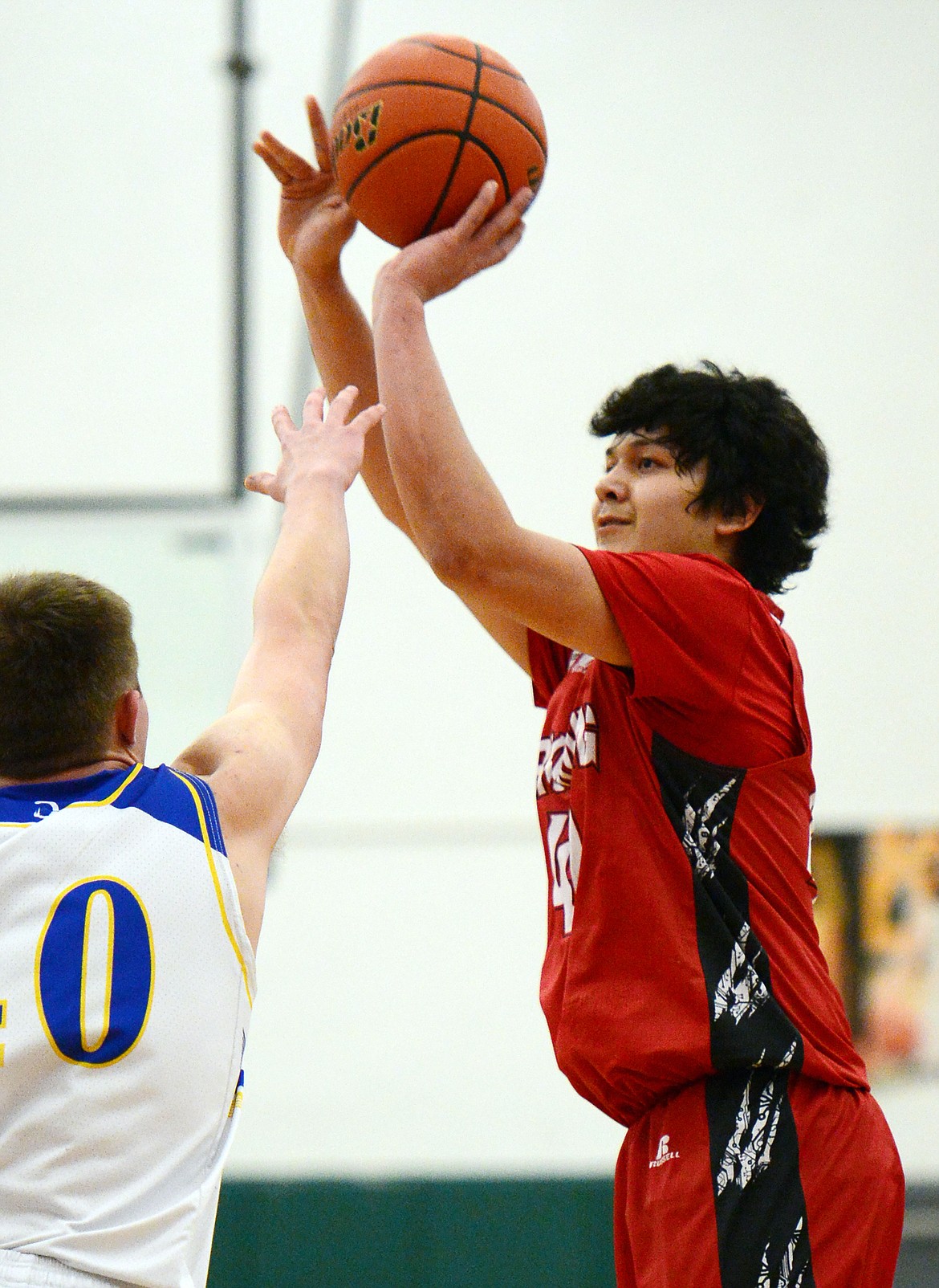 Browning's Tyree Whitcomb (40) shoots over Libby's Tim Goodman (40) at Whitefish High School on Friday. (Casey Kreider/Daily Inter Lake)