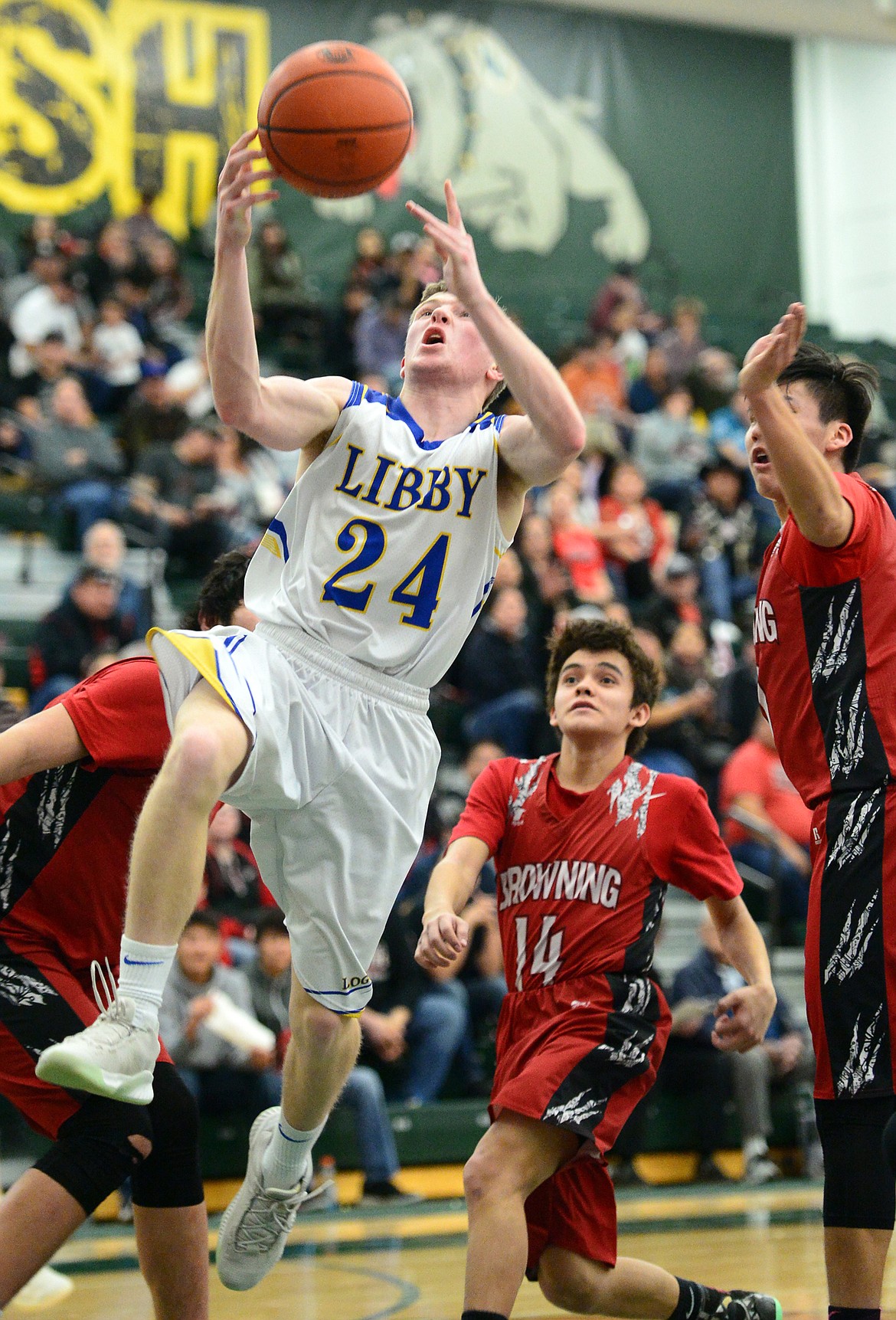 Libby's Jay Beagle (24) is fouled as he drives to the basket against Browning at Whitefish High School on Friday. (Casey Kreider/Daily Inter Lake)