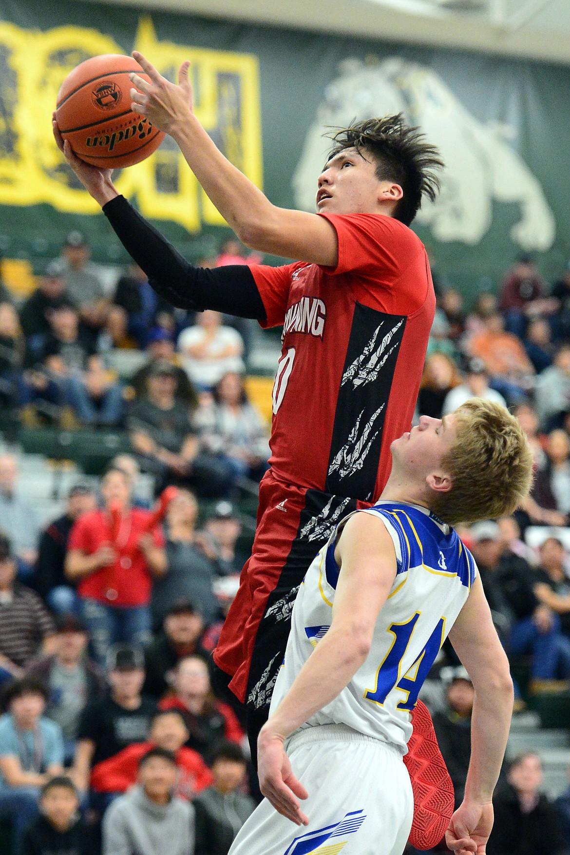 Browning's Riley Spoonhunter (10) drives to the basket past Libby's Chandler Bower (14) at Whitefish High School on Friday. (Casey Kreider/Daily Inter Lake)