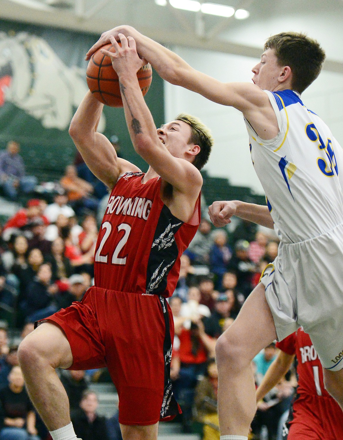 Browning's Brant Bremner (22) drives to the basket with Libby's Caden Williams (30) defending at Whitefish High School on Friday. (Casey Kreider/Daily Inter Lake)