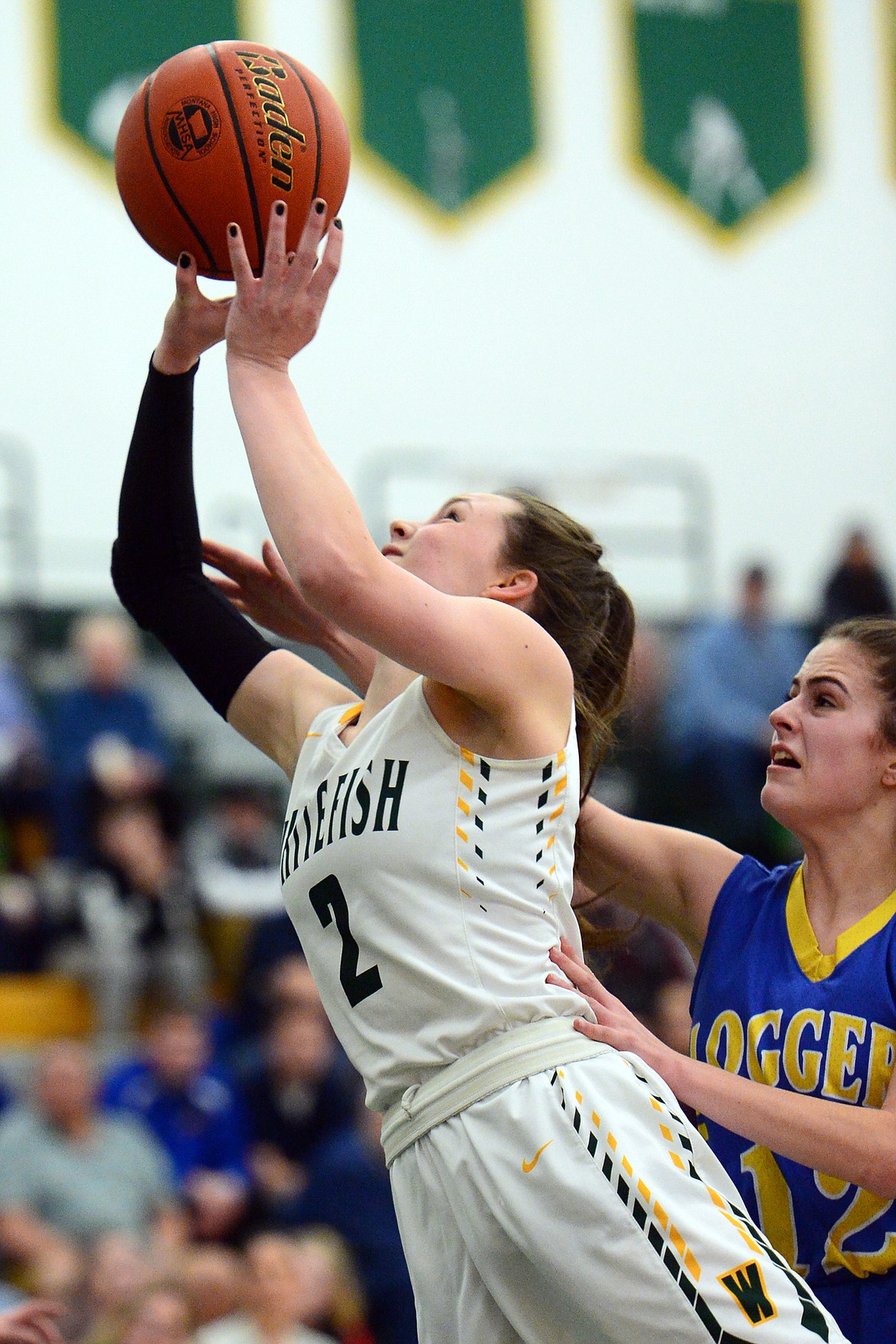 Whitefish's Kaiah Moore (2) drives to the hoop against Libby's Alli Collins (12) at Whitefish High School on Thursday. (Casey Kreider/Daily Inter Lake)